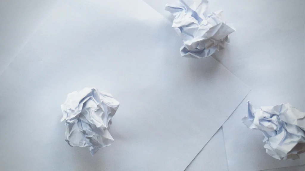 Zerknäultes Papier liegt auf dem Tisch.